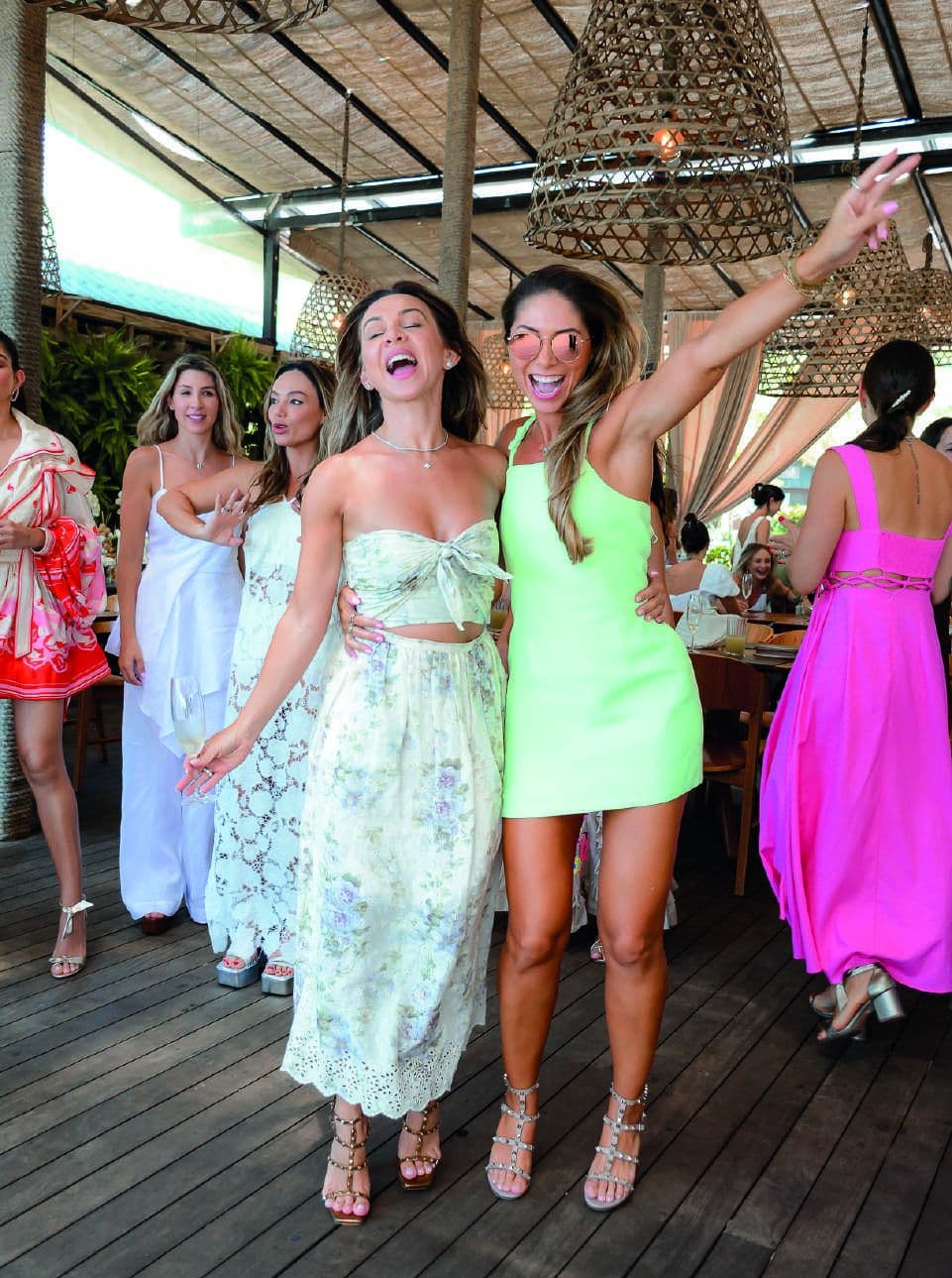 Convidadas brindando e dançando em uma celebração no salão do Amaité